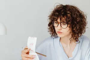 Woman reviewing receipts while working out her budget